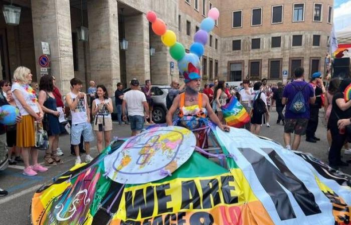 A colorful river of people parades through the city, thousands of people at Varese Pride