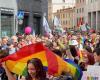 A colorful river of people parades through the city, thousands of people at Varese Pride